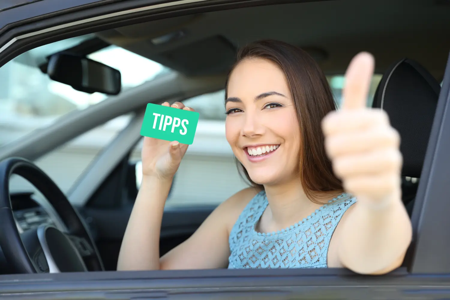 Happy car driver showing a green card with the phrase ''Tips'' on it and with her other hand making thumbs up inside a car.